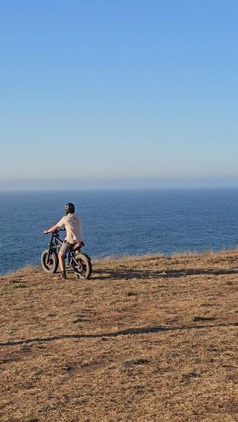 Persona en e-bike detenida en el borde del acantilado frente al mar en Matanzas