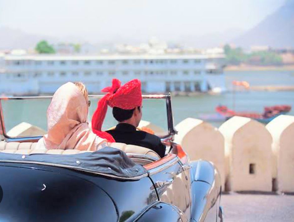 smiling wealthy couple riding in a luxury car