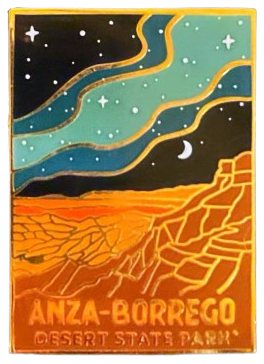 an enamel pin with a starry night sky in three different colors of blue and a desert & waterways below, with the words 'Anza-Borrego Desert State Park' at the bottom