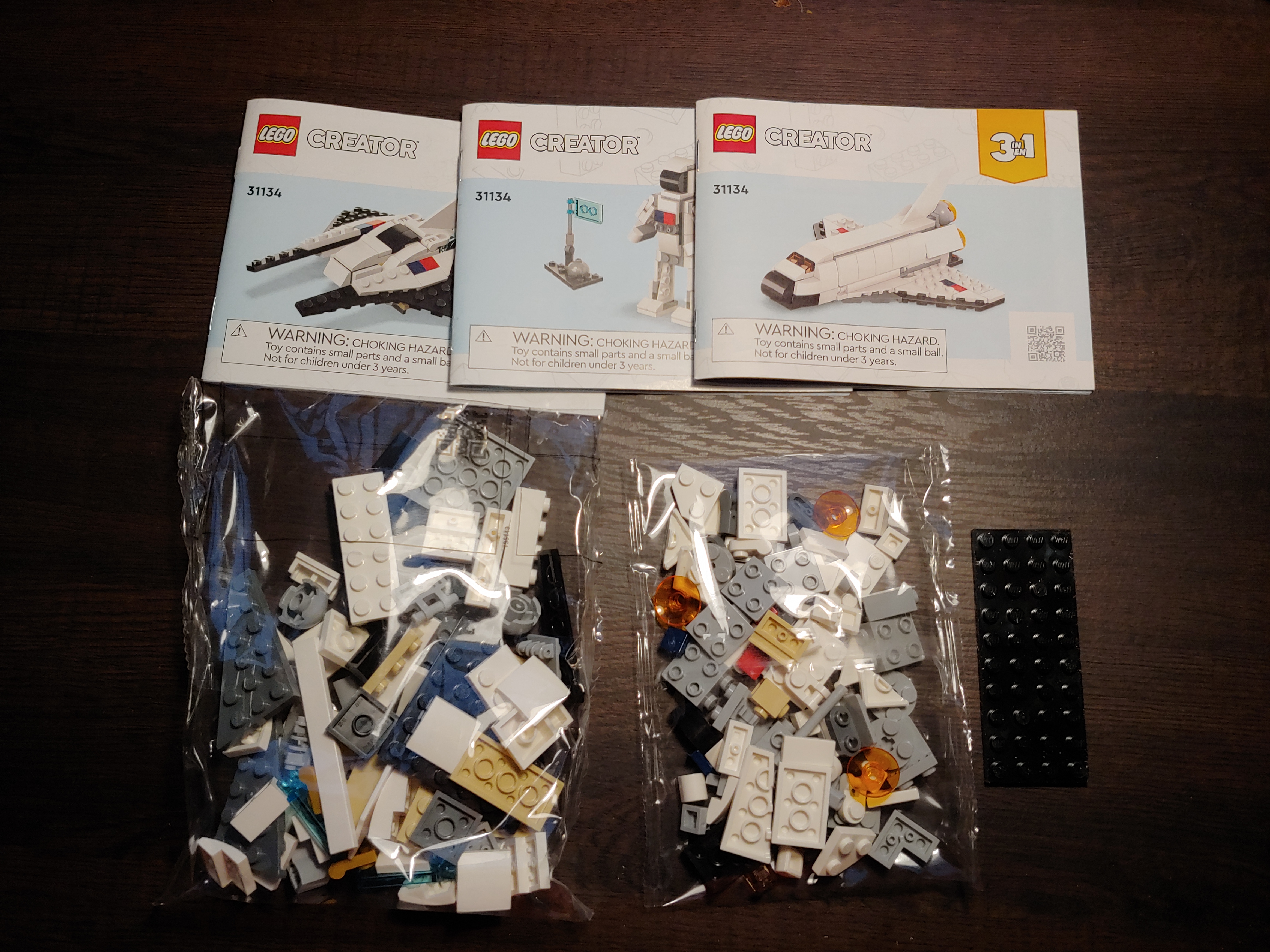 Contents of the box. Two plastic bags containing lego parts, three instruction manuals, and one plate loose in the box.
