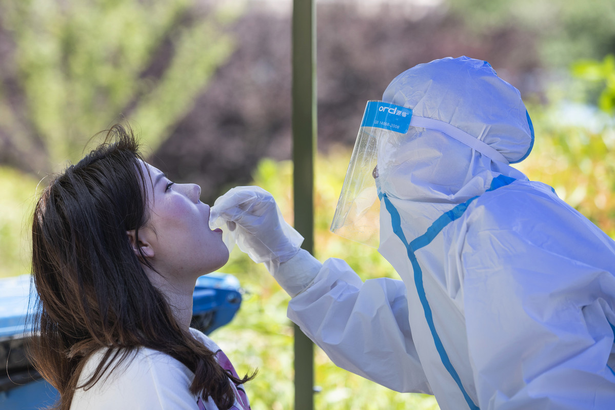 Seorang pekerja medis mengambil sampel swab dari seorang siswa untuk diuji untuk virus corona COVID-19 di Universitas Wuhan, pada hari pertama kelas di Wuhan pada tanggal 8 Juni 2020. Siswa tahun terakhir kembali ke kampus di Wuhan setelah universitas dibuka kembali setelah penutupan selama berbulan-bulan karena coronavirus.