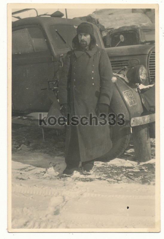 Foto Soldat mit Pelzmütze vor Ford V 8 LKW mit T