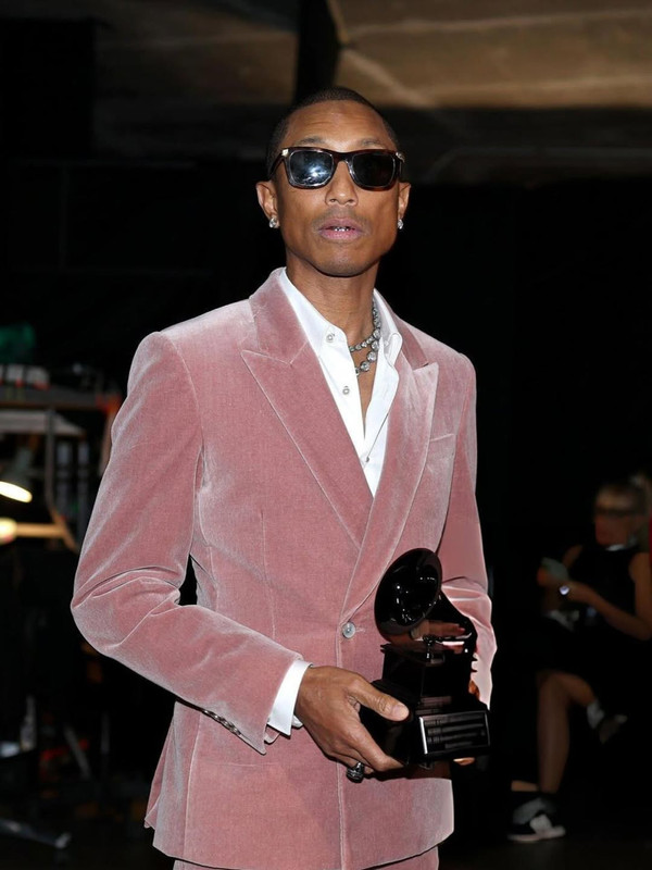 pharrell rising the trophy of Dr Dre Global Impact Award at the Grammys Getty Revolt (3)