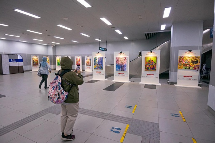 Pengunjung sedang melihat pameran lukisan yang terletak di exit B Stasiun Bundaran HI.