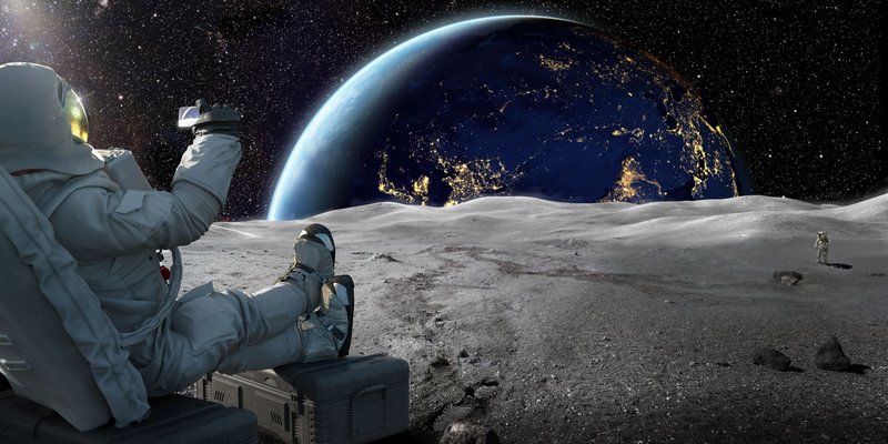 astronaut-sitting-on-moon-recording-sunrise-on-royalty-free-image-1626168417.jpg