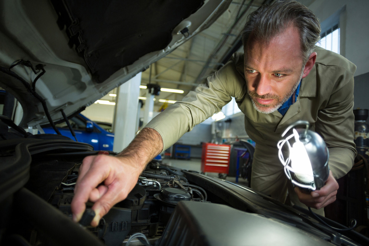 mechanic-examining-car-with-lamp (1)