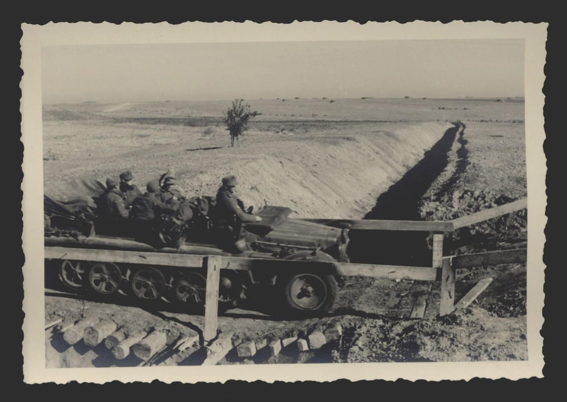 Halbkettenfahrzeug fährt über einen Panzergraben