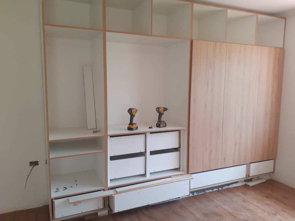 Closet a medida en proceso de armado con cajones abiertos