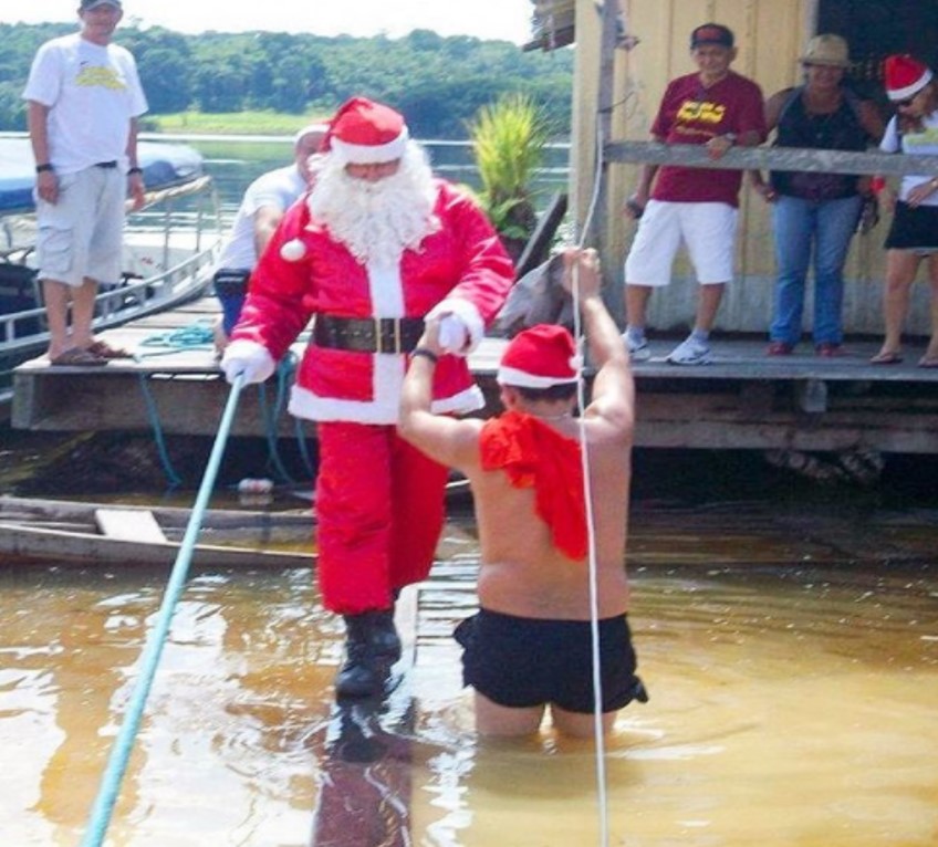 A lancha, Santa Claus lleva el espíritu navideño y regalos a niños en Brasil