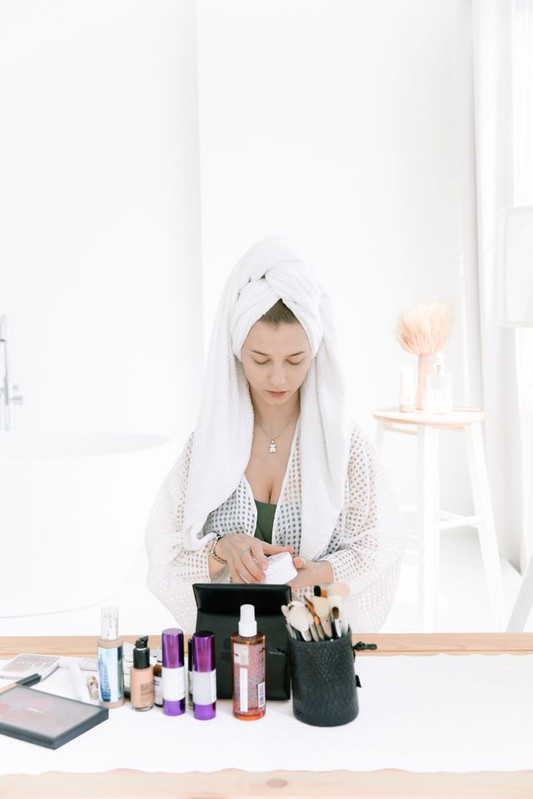 woman prepping her face before foundation to avoid cakey makeup 