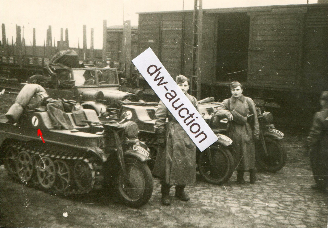 Fallschirmjäger neben Kettengrad mit Wappen vor 