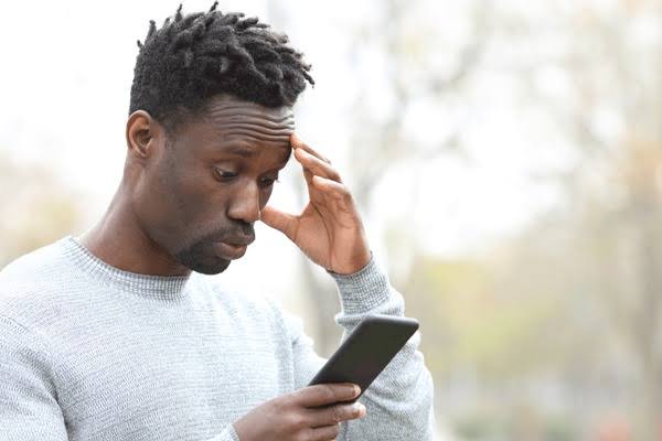 Young man looking frustrated while using dating apps