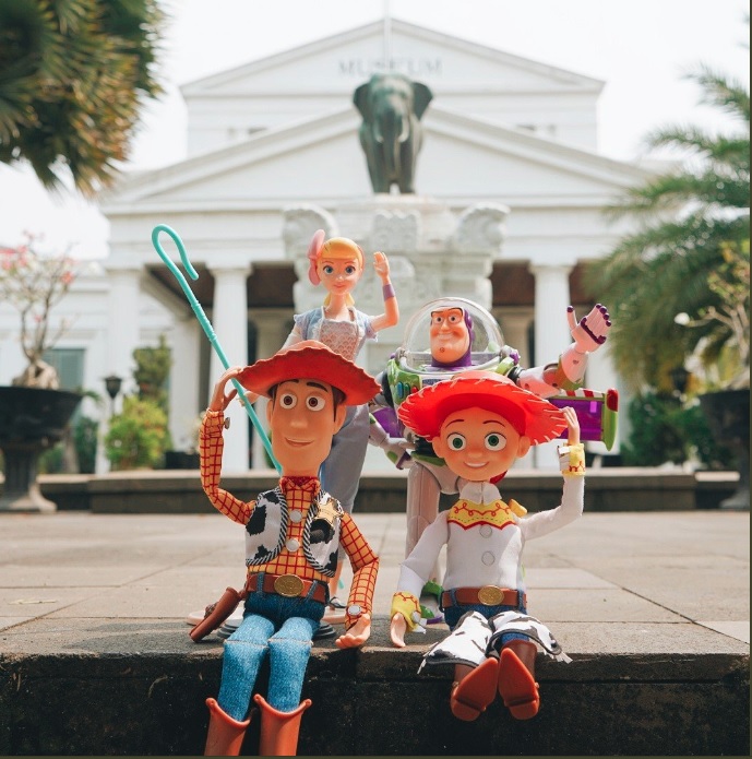 Woody bersama dengan Jessie, Buzz Lightyear dan Bo Peep tampak berpose dengan latar belakang patung gajah di Museum Gajah.