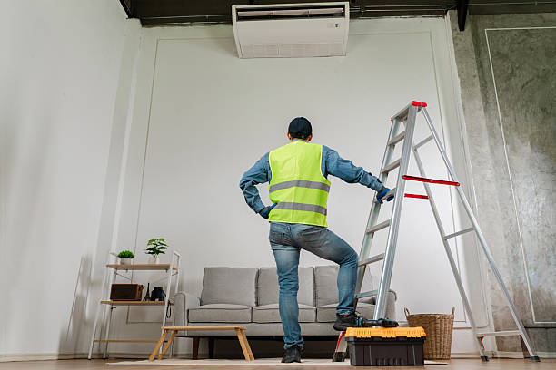 Technician inspecting an air conditioning condenser unit safely