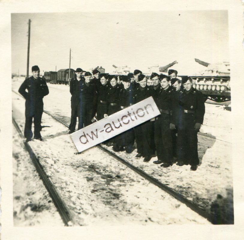 Besatzung vor Panzer mit weißem Tarnanstrich