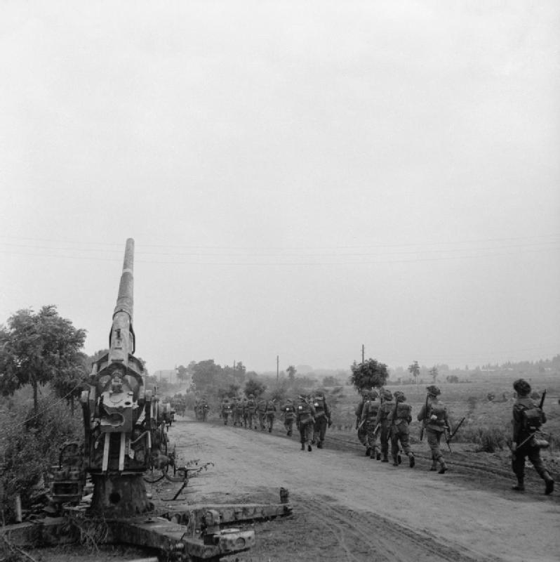 Infantería de la 50ª División Northumbria en marcha junto a de un 88 mm alemán abandonado durante la operación Market Garden