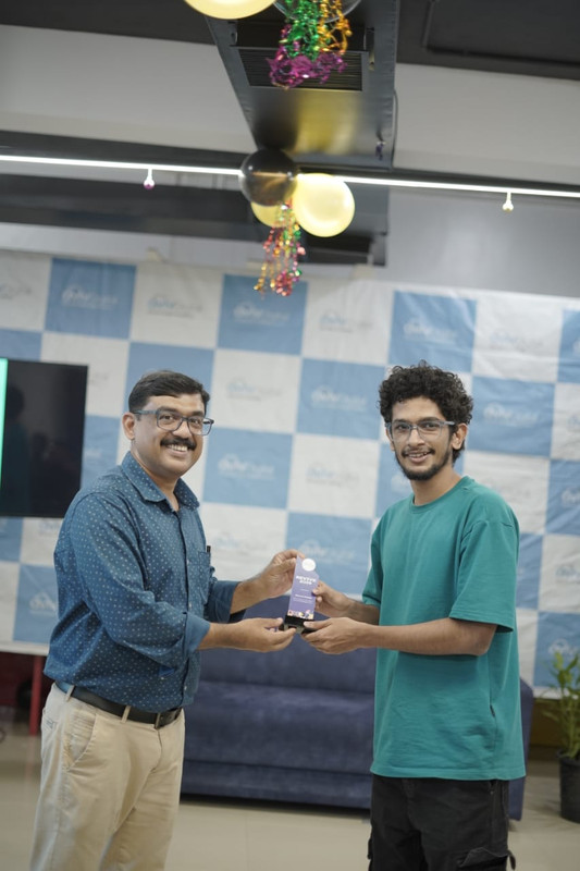 Muhammed Lisan A receiving a memento on stage at an Aviv Digital event