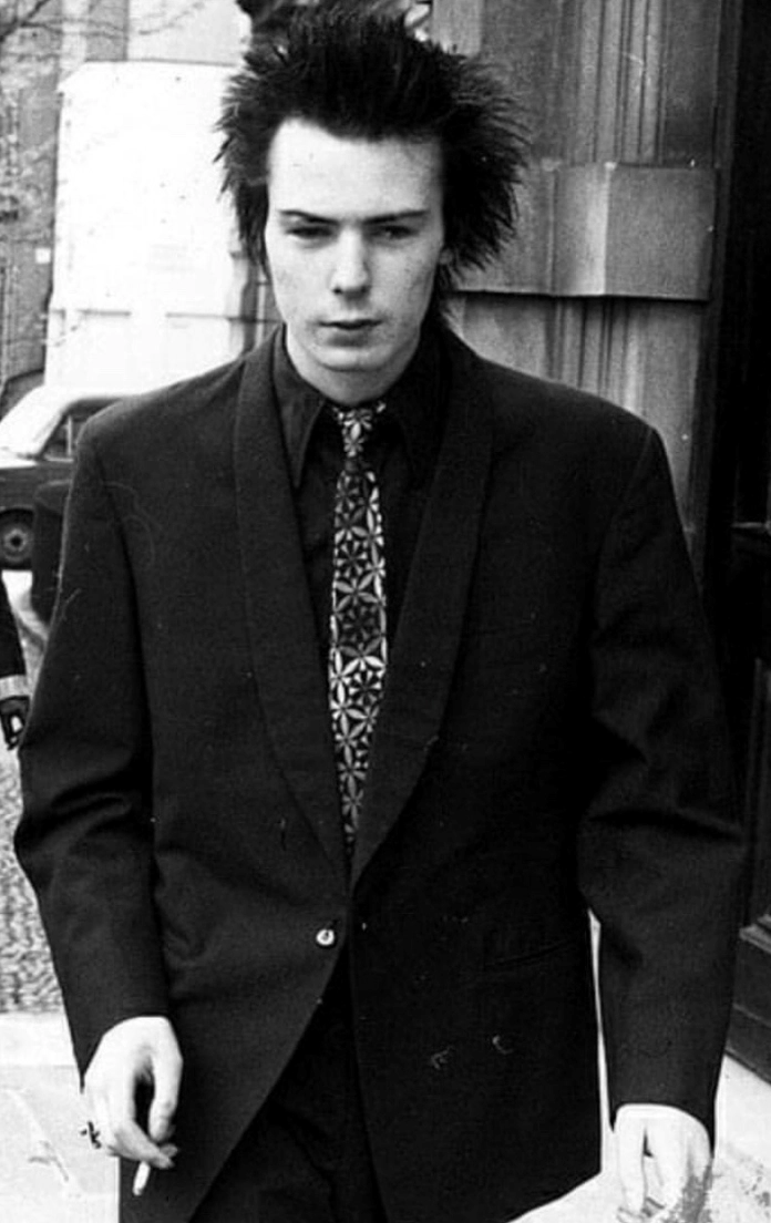 Sid Vicious walks down the street with his distinctive hairstyle