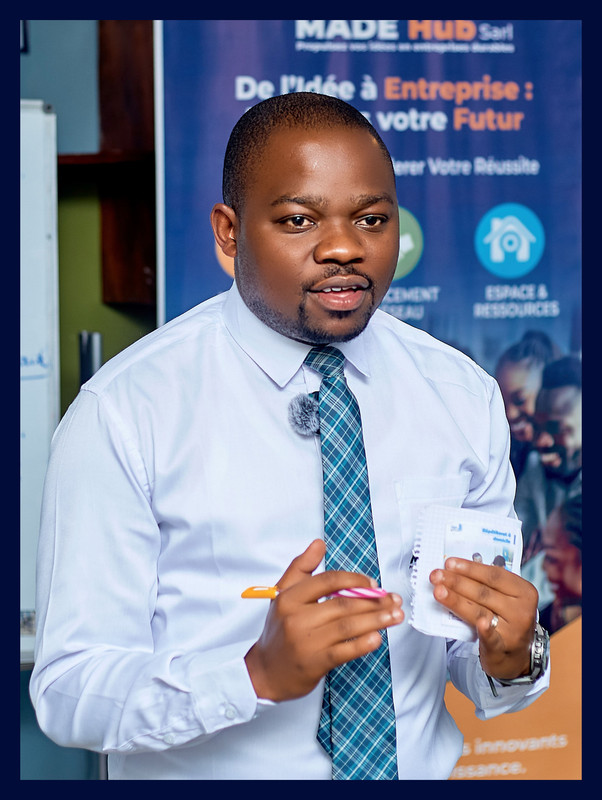 Me Guelord Muhanuka, Business Coach of MADEHub, smiling professional in business attire