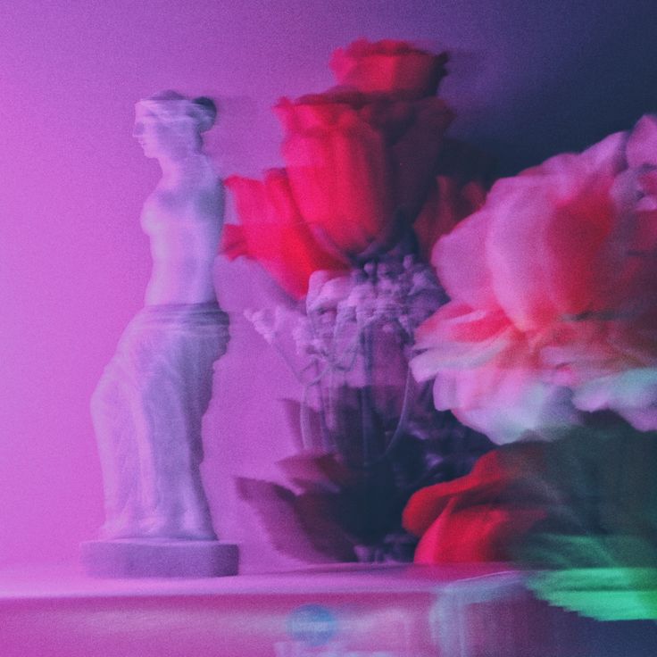 a statue next to a bunch of pink and red flowers in a purple room with a vaporwave vibe