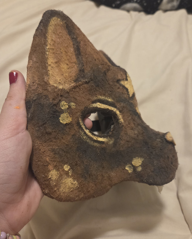 2 of 3. The same mask as the previous image, from a side angle. The mask curves into a feline snout.