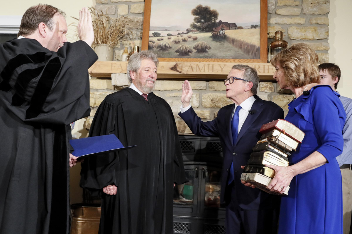 Mike DeWine, center right, is sworn in as the 70th Governor of Ohio alongside his wife & son on Monday, Jan. 14, 2019, in Cedarville, Ohio