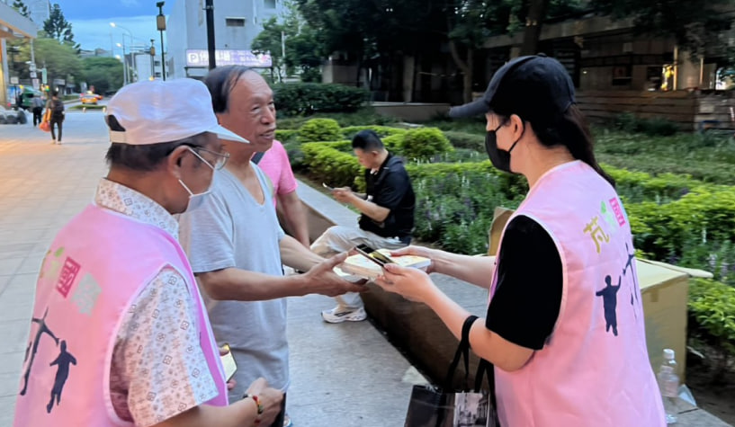 志工在街頭分送物資與便當