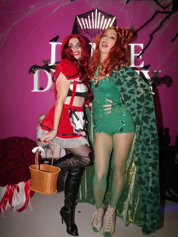 Two guests in red and green costumes goofing around at the photo wall