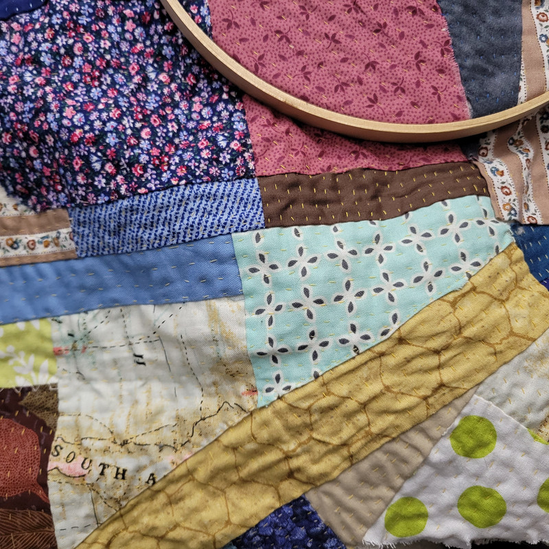 Patchwork with random fabric scraps adhered to muslin