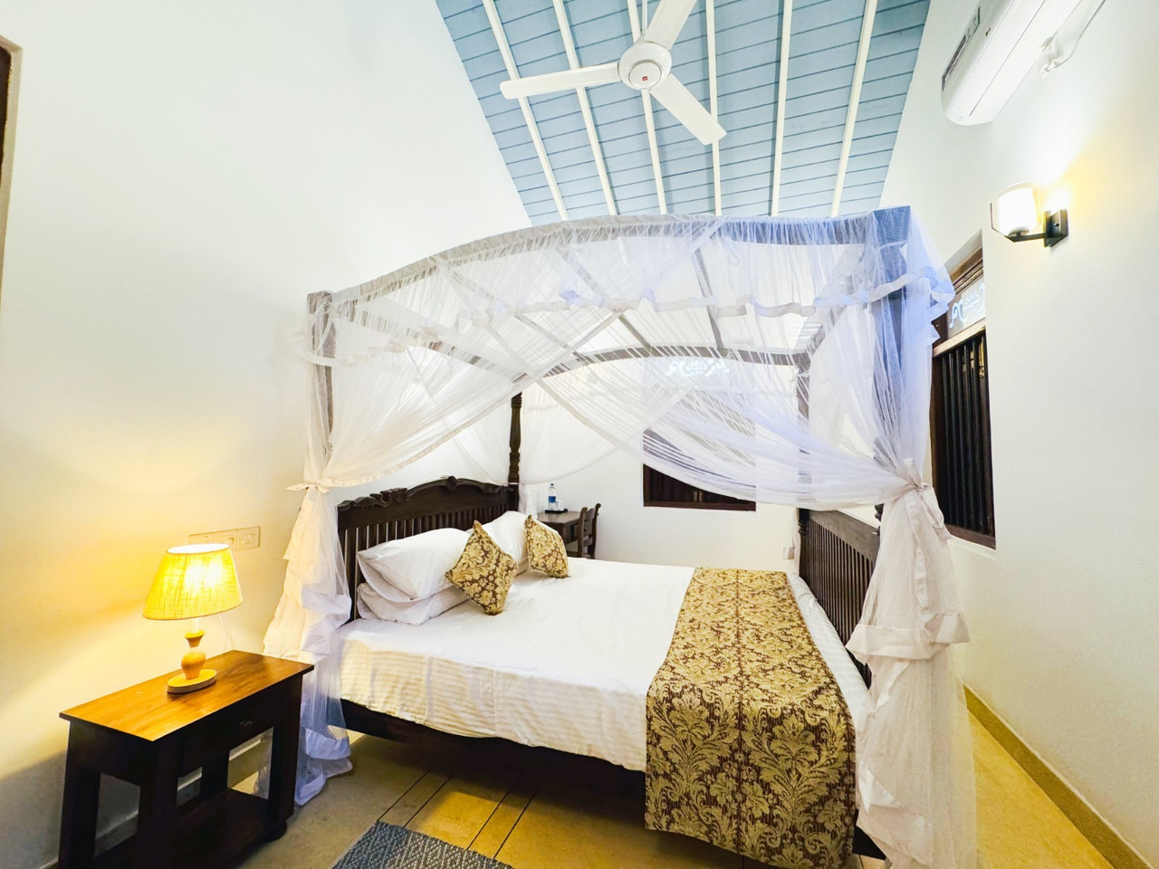 Bedroom with vaulted ceiling and gold accents