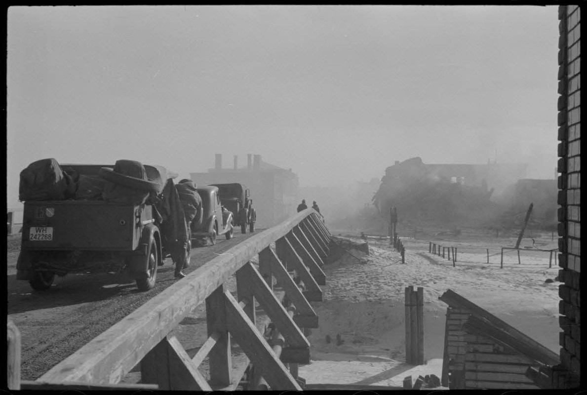 Des véhicules allemands patientent sur un pont avant de quitter Wjasma (Viazma), un insigne en forme