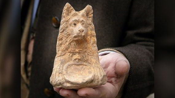 Antica statua con testa di cane trovata durante gli scavi della strada romana
