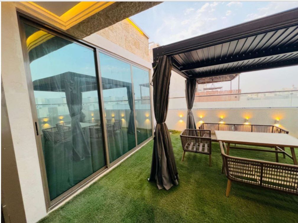 مجلس واسع داخل فيلا فاخرة في عجمان، يجمع بين الفخامة والتصميم العصري ليمنح أجواء راقية للضيافة والاستقبال.`