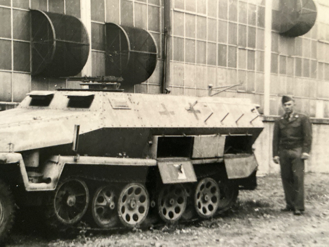 GI posing next to German armored half track vehicle (2)