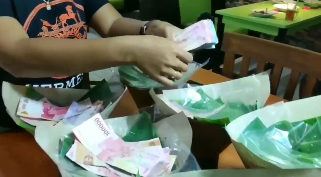 Lembaran uang ratusan ribu yang dimasukkan ke dalam nasi bungkus (Instagram/pratisia.kurniawati)