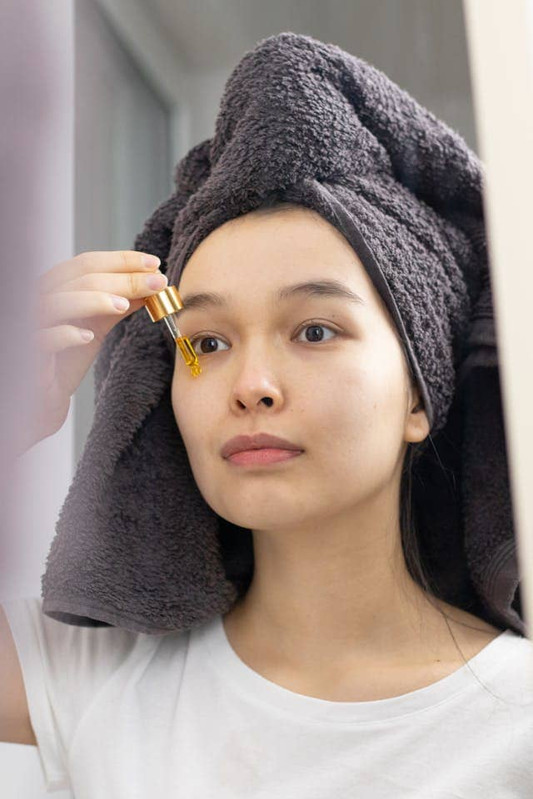 A girl applying antioxidant ingredients to her face 