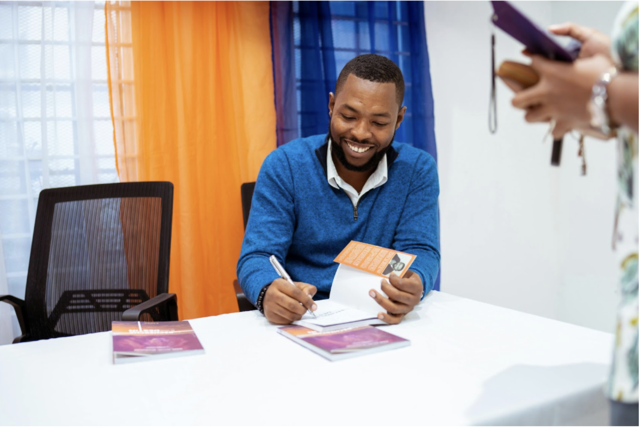 An author signing books during a book launch