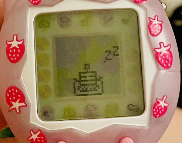 up close photo of a tamagotchi connection device (2024 rerelease) showing ALIBI the robot sleeping peacefully