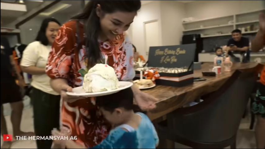 Arsya memberikan kol yang telah dihiasi dengan lilin untuk Ashanty