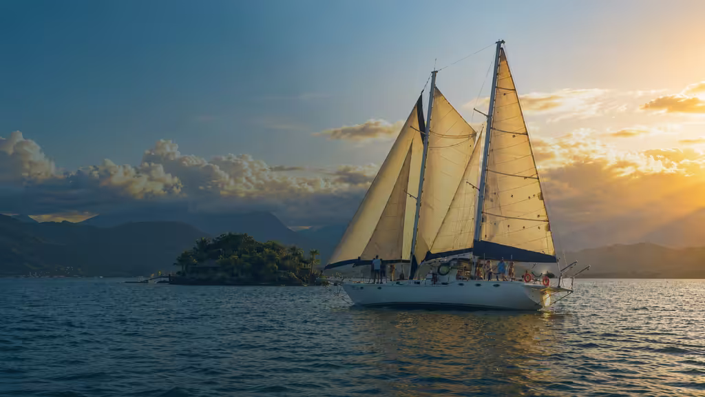 Veleiro Beijupirá navegando ao entardecer em Paraty