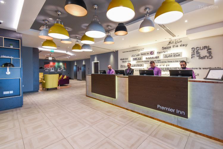 القاعة الرئيسية لفندق Premier Inn Dubai International Hotel مع وجود موظفي الاستقبال