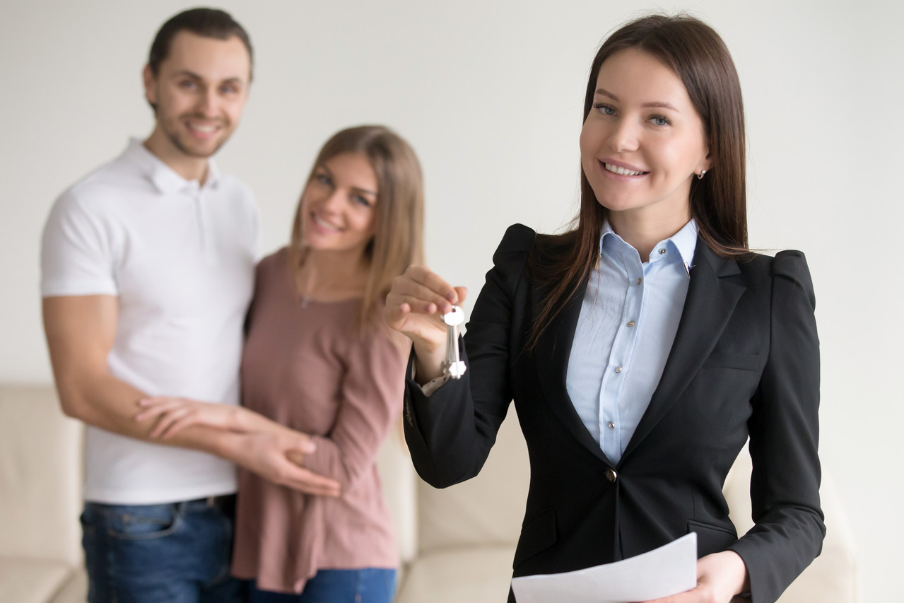 real estate deal female smiling realtor showing keys flat