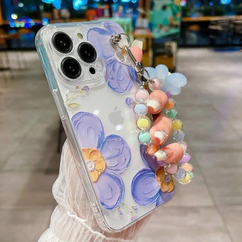 Foto de Funda transparente con diseño flora. Incluye correa de mano.