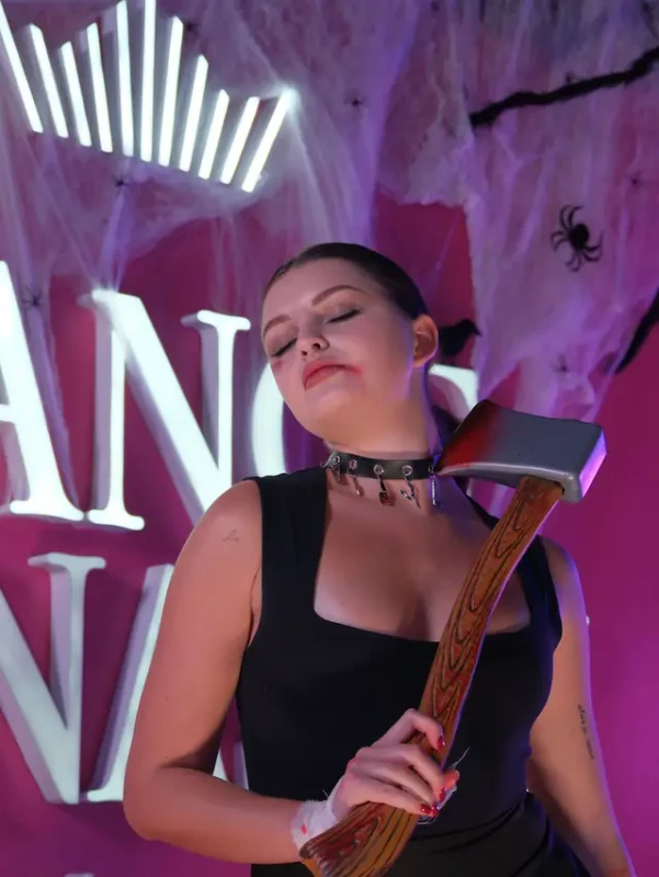 A guest with a prop axe and a studded choker