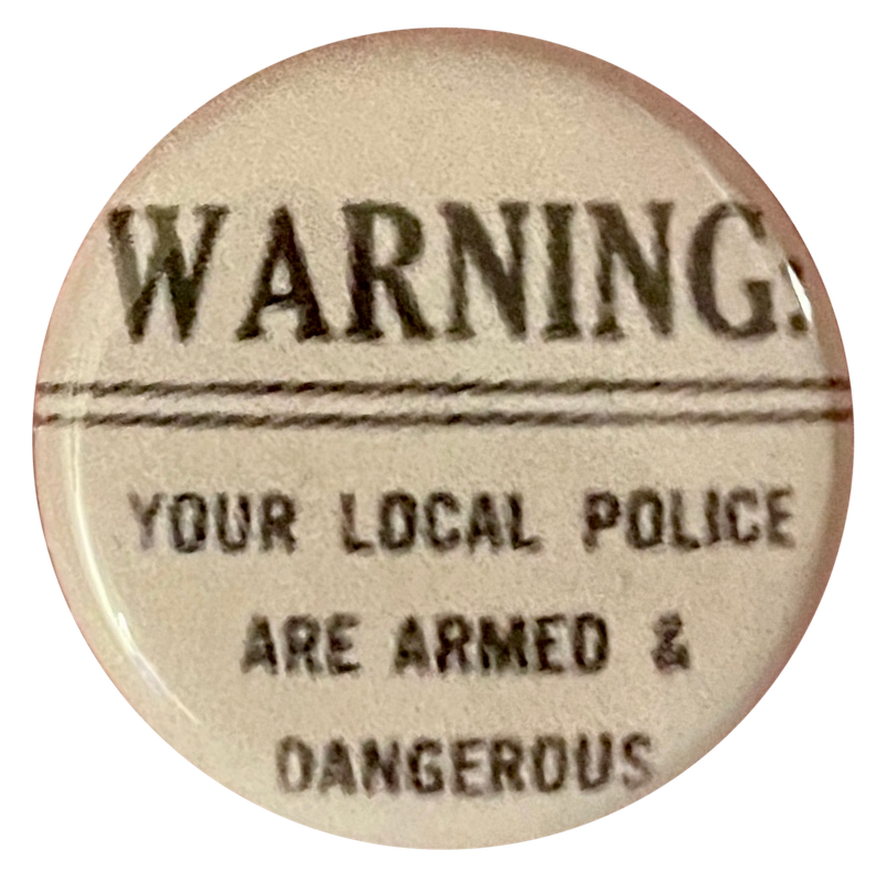 a white pin with black text that say 'WARNING! your local police are armed & dangerous'