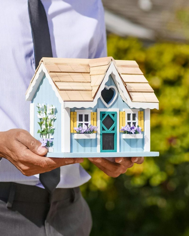 Person holding a model house