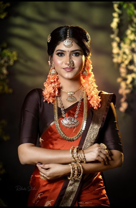 Kandyan bride in orange saree with jasmine flowers by Princess Beauty Center