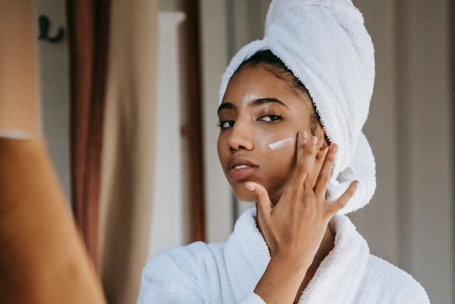  a woman applying glycerin containing moisturizer on face to keep her dry skin supple, soft and smooth. 
