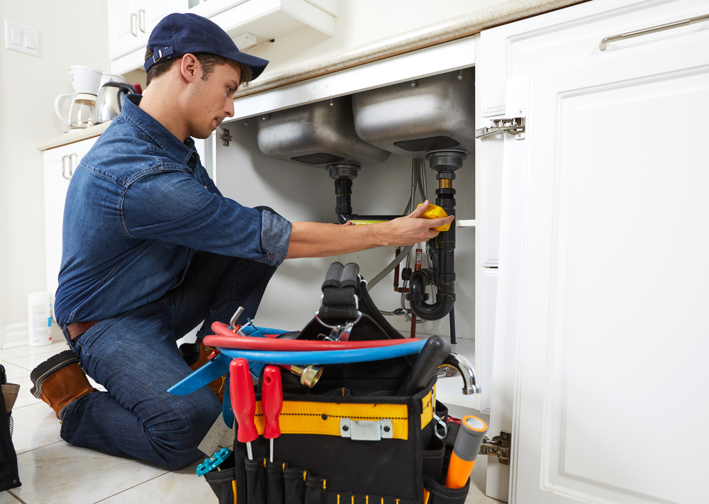 Professional plumber fixing pipes
