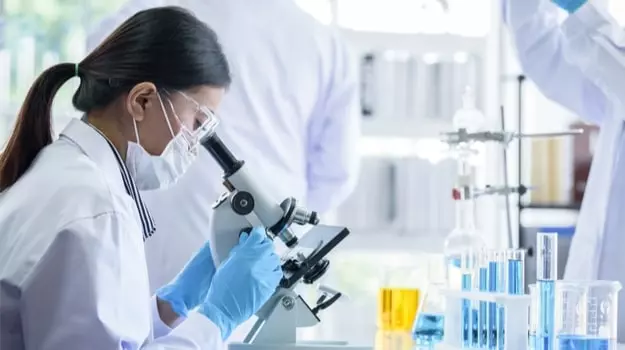 Scientist examining nanotechnology through microscope